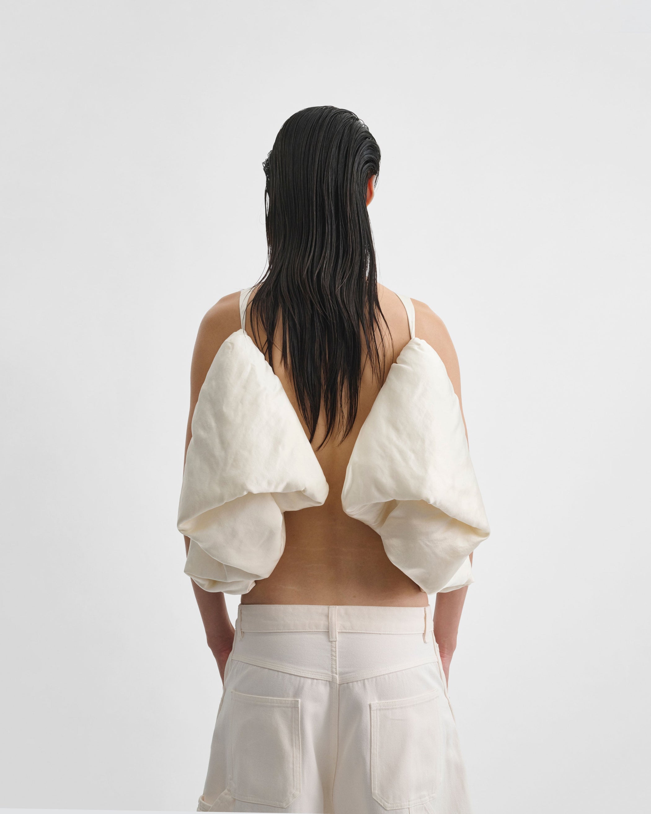 Back view of model wearing SUGAR VEST in vanilla silk satin