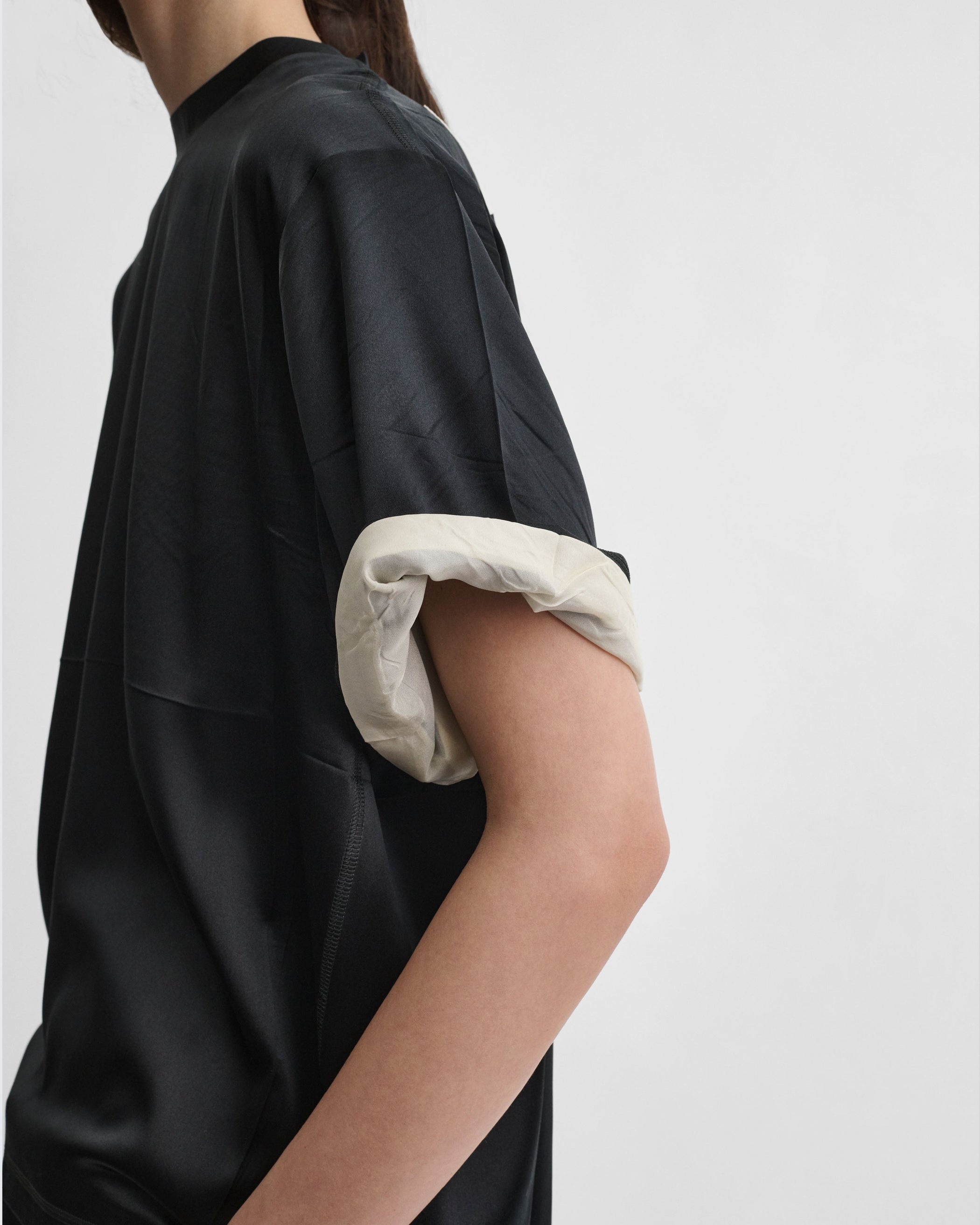 Detail view of model wearing GRAPHIC TRAIN TEE in black silk