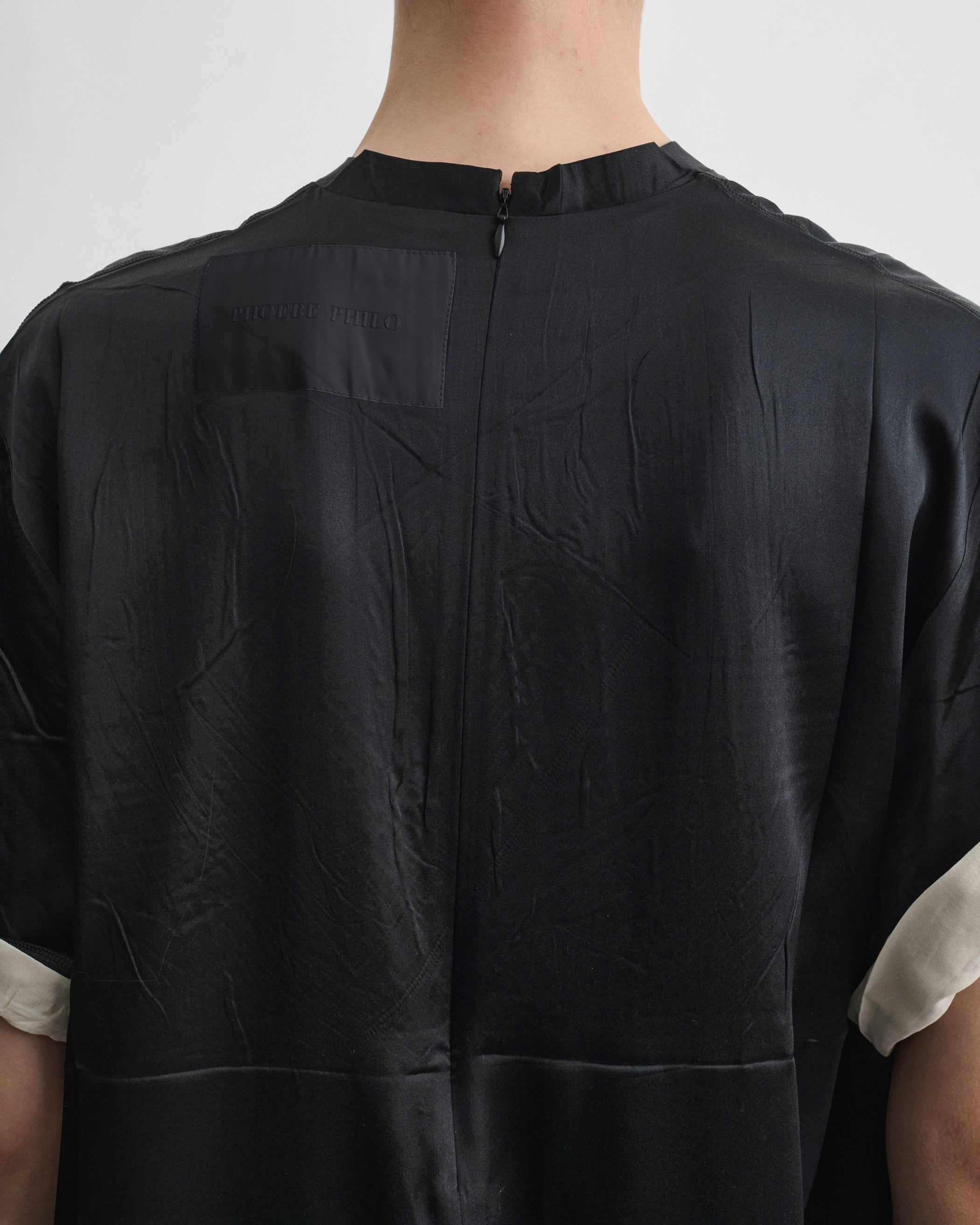 Back view of model wearing GRAPHIC TRAIN TEE in black silk