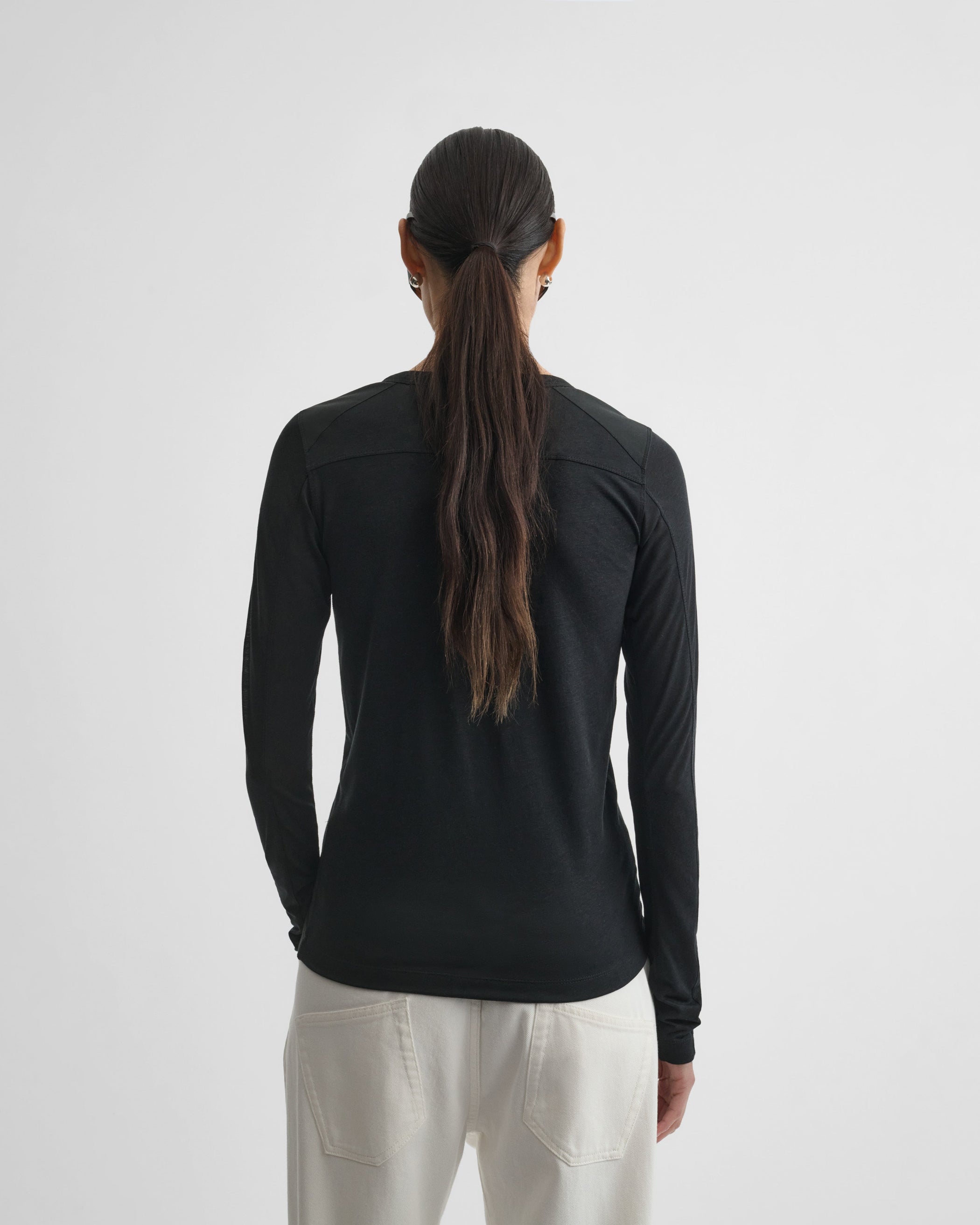 Back view of model wearing CREW NECK TOP in black cotton