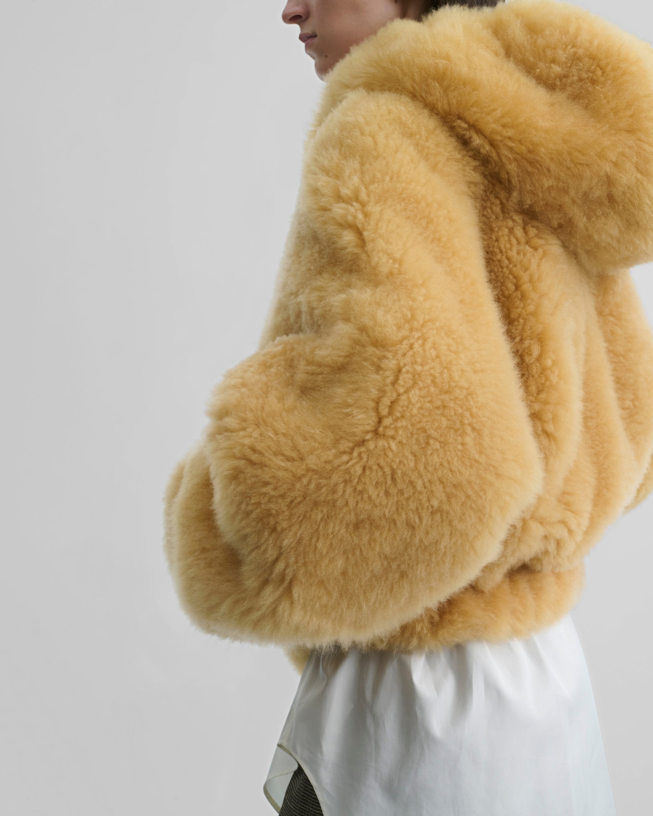 Detail side view of model wearing SUPER TEDDY HOODIE in honeycomb shearling